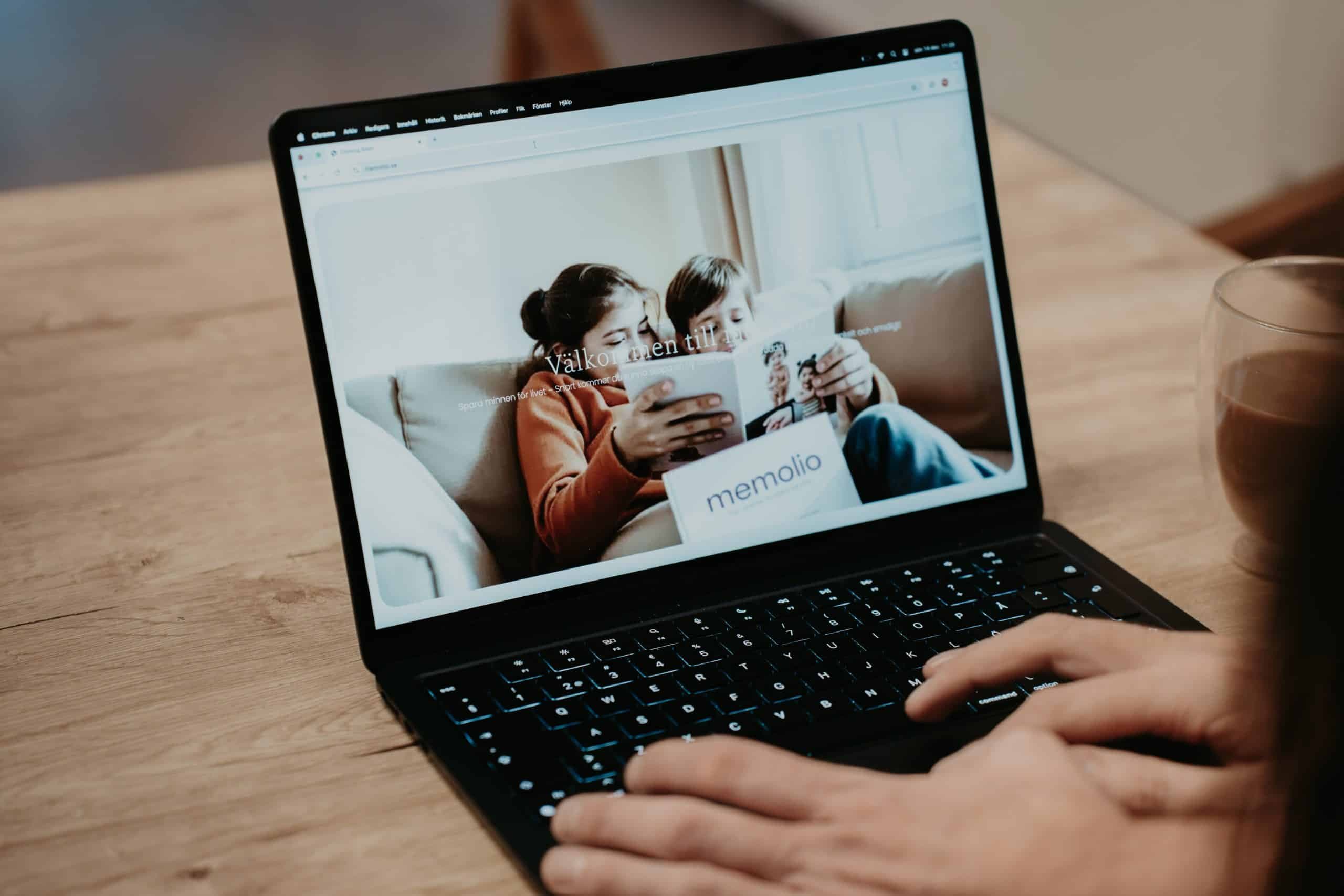 En person tittar på memolio.se i en laptop